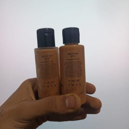 Two bottles of MCE sun screen fluid held in a hand against a white background